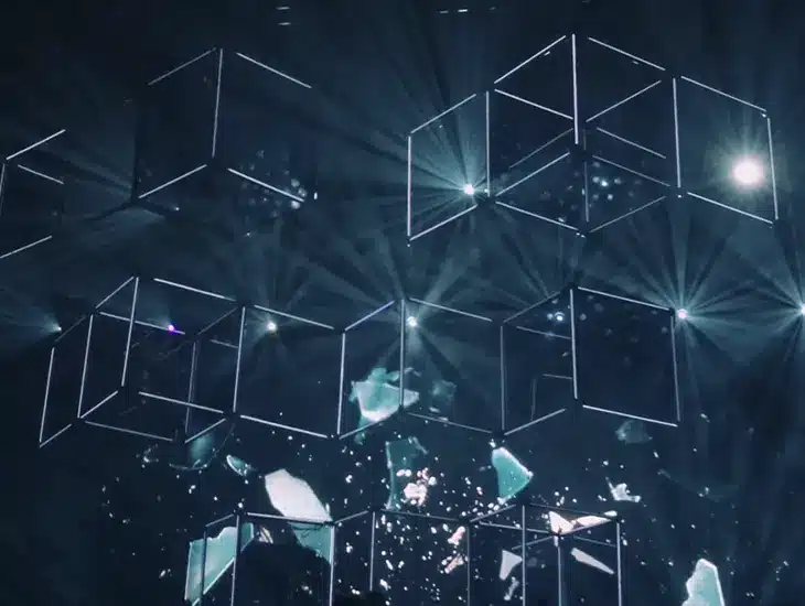 A stage adorned with a multitude of cubes in the background, while showcasing a Letter from Symphonic's CEO.