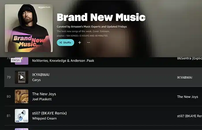 A music playlist titled "Brand New Music" is displayed on a screen, featuring a list of recently updated songs, with the top track being "IKYABWAI" by Carys.