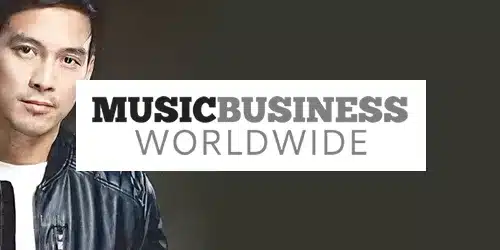 A press photo reveals a man's partial image in a leather jacket beside the "MUSIC BUSINESS WORLDWIDE" text on a dark background.