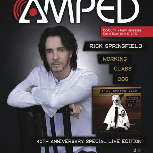 Rick Springfield poses with arms crossed on the cover of AMPED magazine, celebrating the 40th anniversary edition of his album "Working Class Dog" and highlighting its physical music distribution.